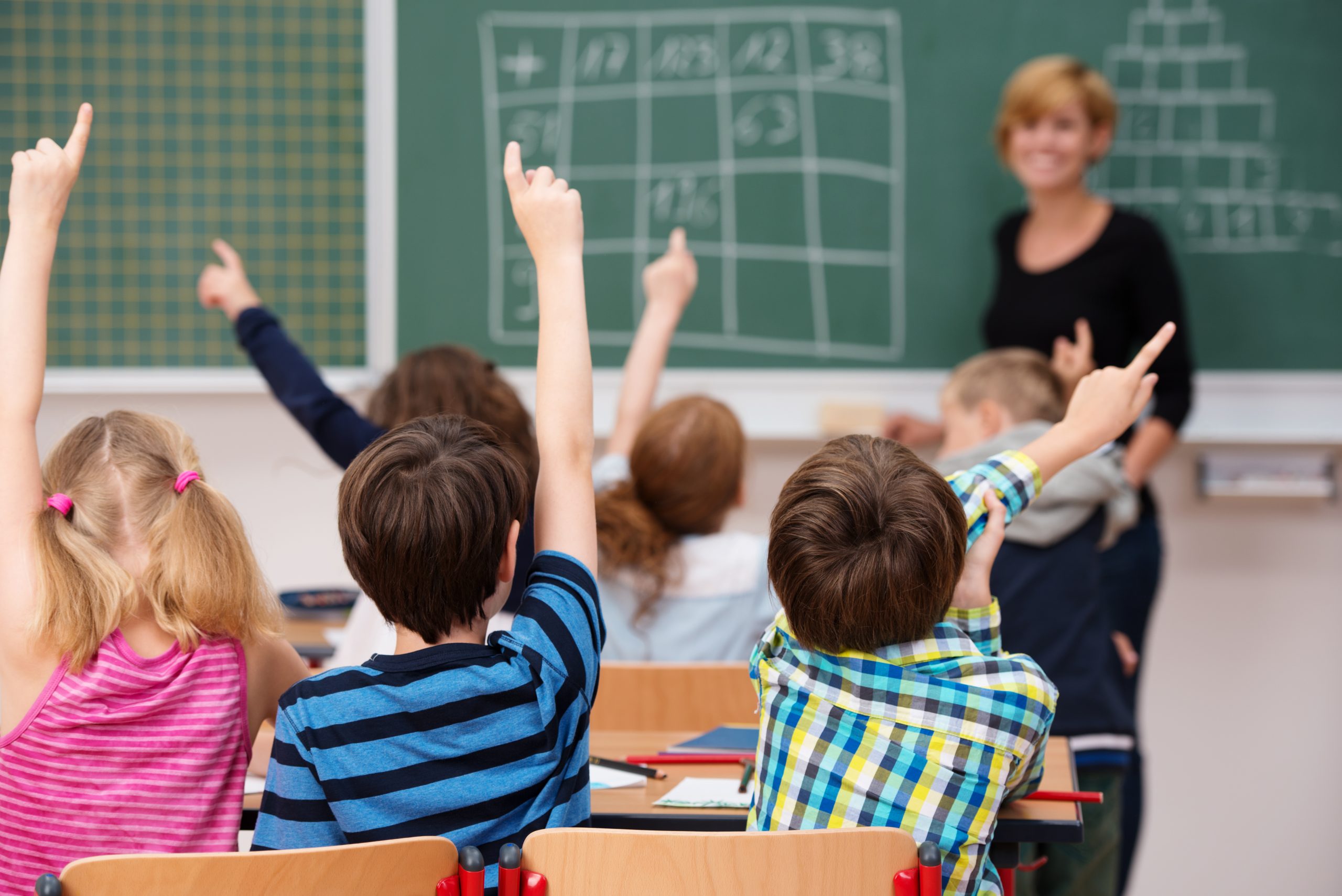 Intelligent,Group,Of,Young,School,Children,All,Raising,Their,Hands