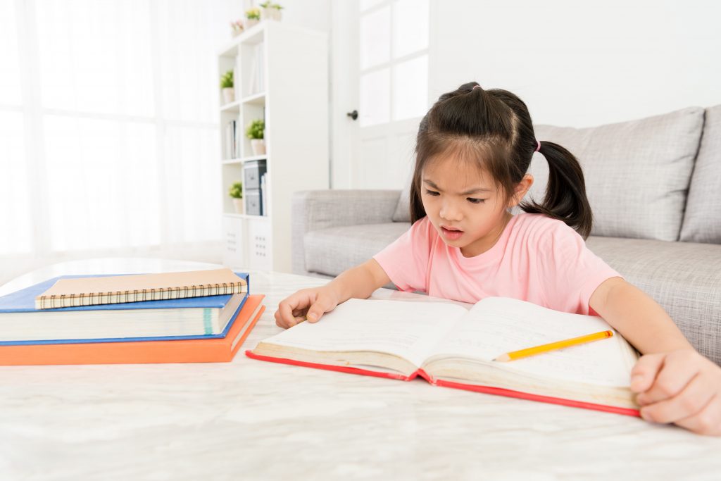 Lovely,Pretty,Female,Little,Kid,Student,Looking,At,School,Textbook การแก้โจทย์เลขอาจเป็นเรื่องยากสำหรับนักเรียน
