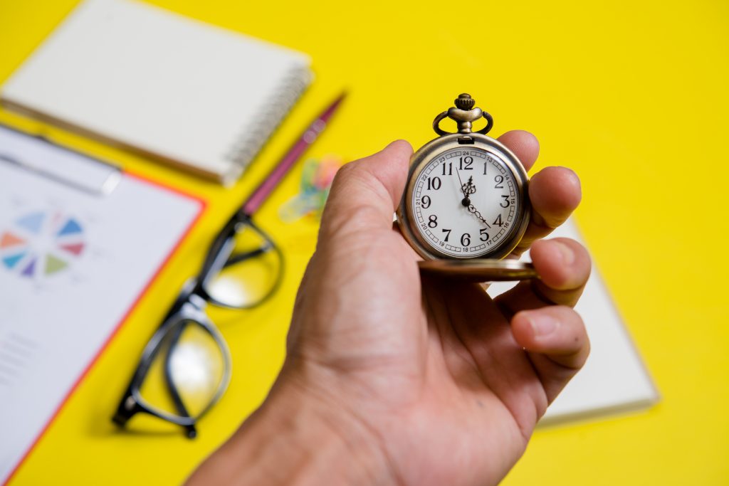 Close up hand holding clock, business concept จิตวิทยาเบื้องหลังการบริหาร 4,000 สัปดาห์ของชีวิต